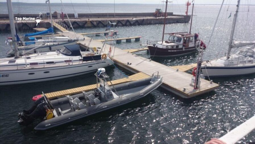 Flytbrygga med betongpontoner och gångbara Y-bommar i marina
