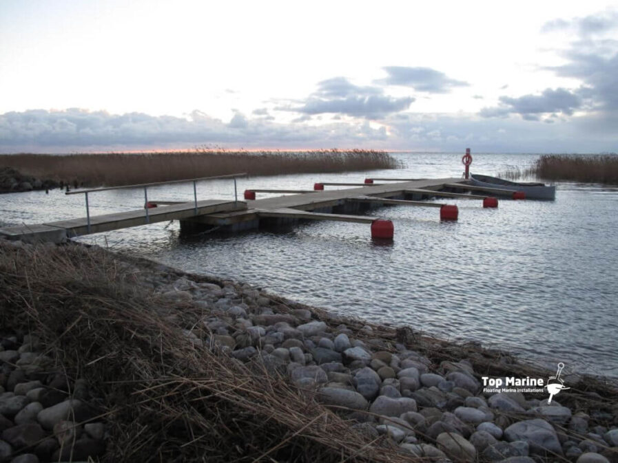 Flytbrygga med plastpontoner i småbåtshamn vid kust